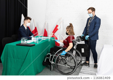 A young adult in a wheelchair came to the polling station to vote for president in the elections in Poland. A young adult in a wheelchair came to the polling station to vote for president in the elections in Poland. 116861409