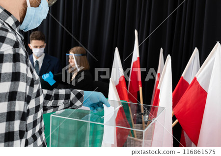 The young voter throws into the ballot box his votes for the new candidate for the new president of Poland. The young voter throws into the ballot box his votes for the new candidate for the new president of Poland. 116861575