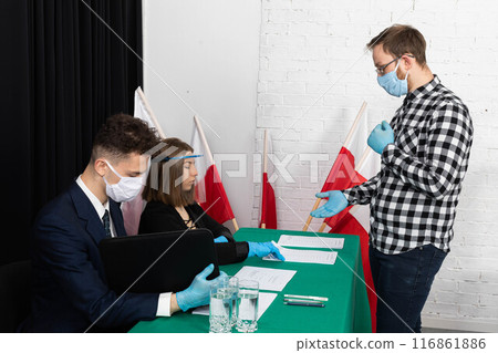 The man collects the electoral card to vote for his Polish presidential candidate. 116861886