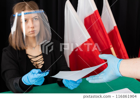 The man collects the electoral card to vote for his Polish presidential candidate. 116861904