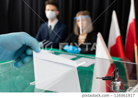 The young voter throws into the ballot box his votes for the new candidate for the new president of Poland. The young voter throws into the ballot box his votes for the new candidate for the new president of Poland. 116861917