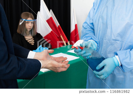 The man from the electoral commission thoroughly disinfects his hands before starting work in the polling station. The man from the electoral commission thoroughly disinfects his hands before starting work in the polling station. 116861982