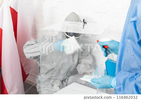 Two employees disinfect the ballot box before the presidential election in Poland. 116862032