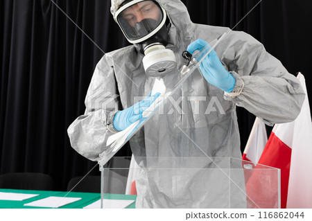 An employee in a special overalls and a filter mask thoroughly disinfects the polling station. Presidential election in Poland. An employee in a special overalls and a filter mask thoroughly disinfects the polling station. Presidential election in Poland. 116862044