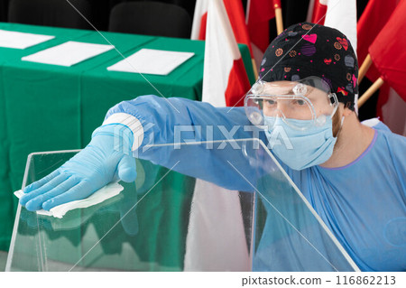 The employee during disinfection tries to thoroughly clean every inch of the ballot box to avoid infection. 116862213