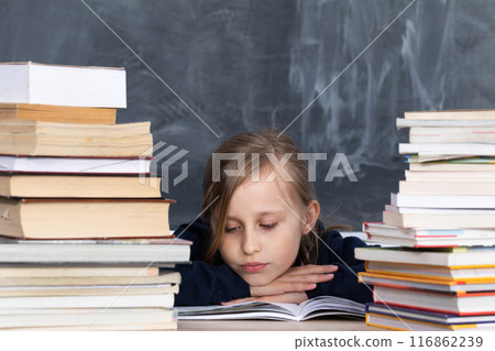 The student is preparing in the school bench for the exam which will take place soon. Stack of school readings. The student is preparing in the school bench for the exam which will take place soon. Stack of school readings. 116862239