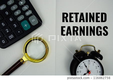 Retained Earnings text message written on note page with calculator, alarm clock and magnifying glass 116862738
