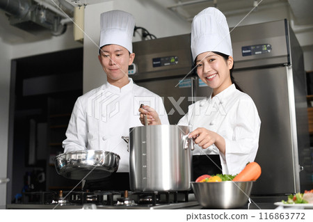 Young asian male and female chefs cooking in the kitchen Young asian male and female chefs cooking in the kitchen 116863772