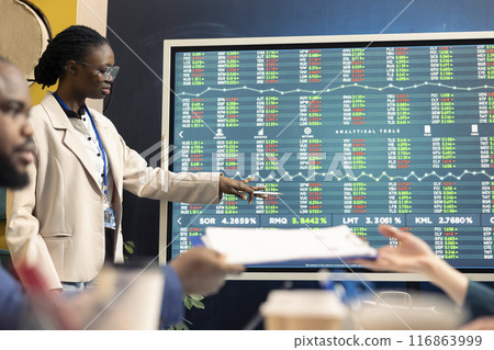 Team of business analysts following stock trade numbers on interactive board, developing a new financial strategy to increase funding. Forecast affiliates working on organizational success. Team of business analysts following stock trade numbers on interactive board, developing a new financial strategy to increase funding. Forecast affiliates working on organizational success. 116863999