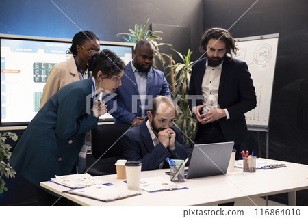 Business workers analyzing project updates and details to ensure goal achievement, evaluating statistics data on laptop and finding ways to obtain new capital. Enterprise management team. 116864010