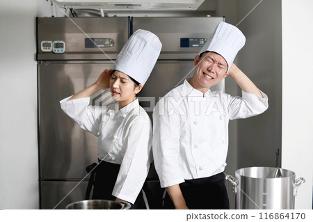 Young Asian male and female chefs worried in the kitchen Young Asian male and female chefs worried in the kitchen 116864170