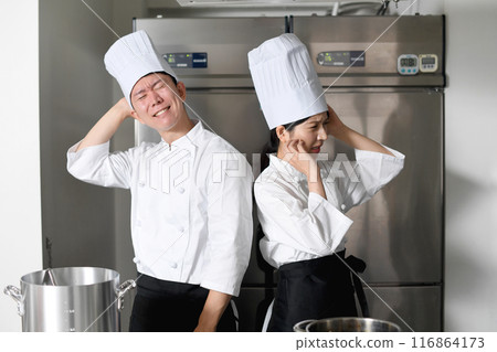 Young Asian male and female chefs worried in the kitchen Young Asian male and female chefs worried in the kitchen 116864173
