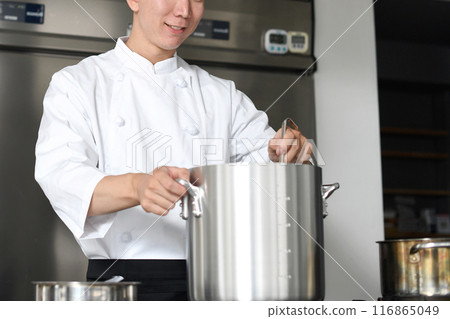 Young asian male chef preparing food in the kitchen Young asian male chef preparing food in the kitchen 116865049