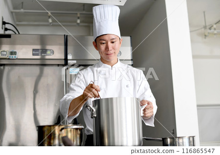 年輕的亞洲男廚師在廚房做飯 年輕的亞洲男廚師在廚房做飯 116865547