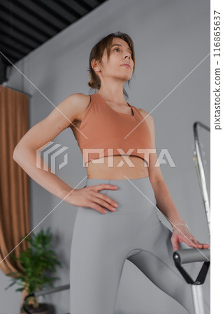 A detailed closeup of a foot work and core exercise on a Balanced Body Chair machine illuminated by sunlight A detailed closeup of a foot work and core exercise on a Balanced Body Chair machine illuminated by sunlight 116865637