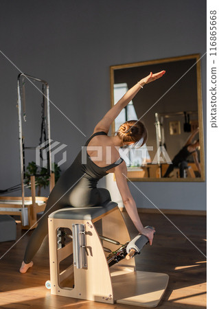 Woman doing mermaid exercise in a sunlite modern studio, embodying calm, focus, and strength. Woman doing mermaid exercise in a sunlite modern studio, embodying calm, focus, and strength. 116865668