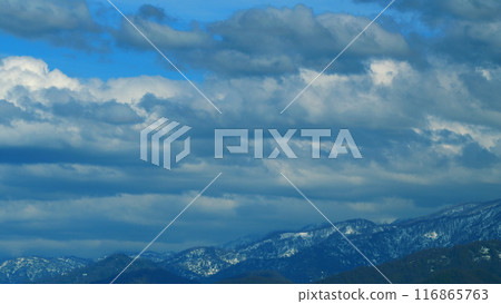 The Rays Of The Sun Fall On Part Of The Clouds. Mountain In The Distance Is Covered With Snow. Timelapse. 116865763