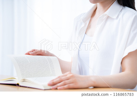 A woman reading a book in the living room [Part cut] 116865783