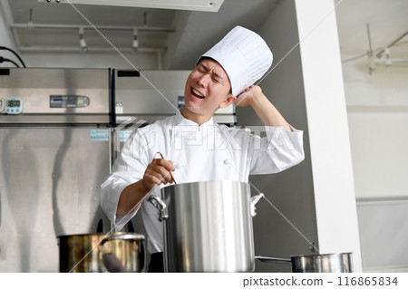 Young Asian male chef worried in the kitchen Young Asian male chef worried in the kitchen 116865834