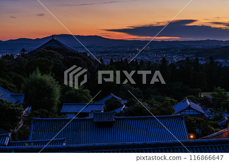 Summer 2024: Evening view of Nigatsudo Hall at Todaiji Temple in Nara. The western sky gradually darkens. The vermilion sunset and the temple grounds are lit up. 116866647
