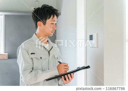 A man in work clothes working for a home builder or remodeler checking his house A man in work clothes working for a home builder or remodeler checking his house 116867786