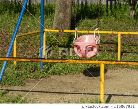 A swing in the park bathed in the summer sunshine 116867931