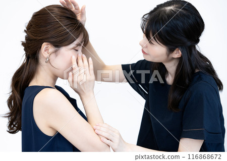 A middle-aged woman comforting a sad young woman A middle-aged woman comforting a sad young woman 116868672