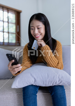 The woman uses her credit card to make online purchases, browsing various stores on her smartphone mobile. The woman uses her credit card to make online purchases, browsing various stores on her smartphone mobile. 116869121