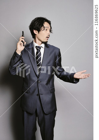 Man on the phone on a grey background 116869625