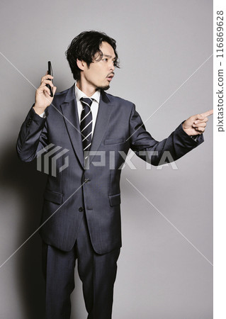 Man on the phone on a grey background 116869628