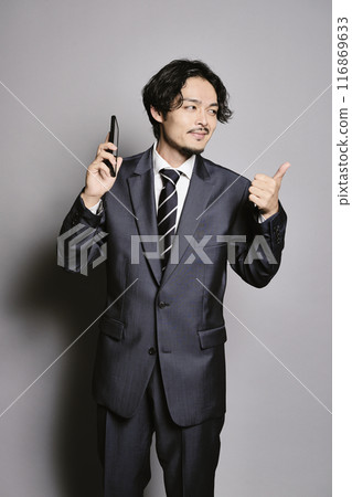 Man on the phone on a grey background 116869633