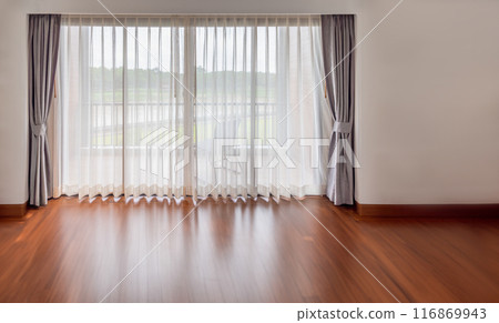 Interior of empty living room with large bright window and white curtains in empty room 116869943