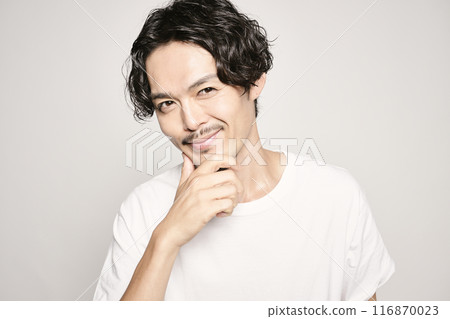 A man holding his hand on his cheek against a white background A man holding his hand on his cheek against a white background 116870023