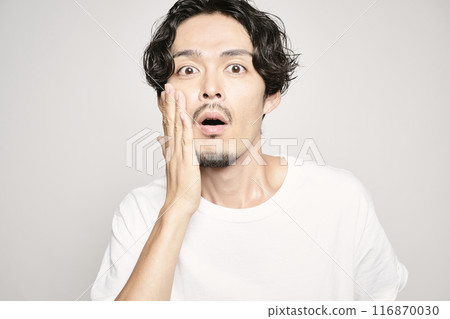 白色背景下,一個男人把手放在臉頰上 白色背景下,一個男人把手放在臉頰上 116870030