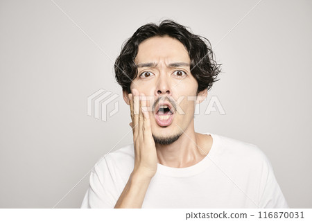 白色背景下,一個男人把手放在臉頰上 白色背景下,一個男人把手放在臉頰上 116870031