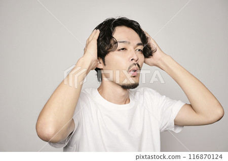 A man touching his hair on a white background 116870124