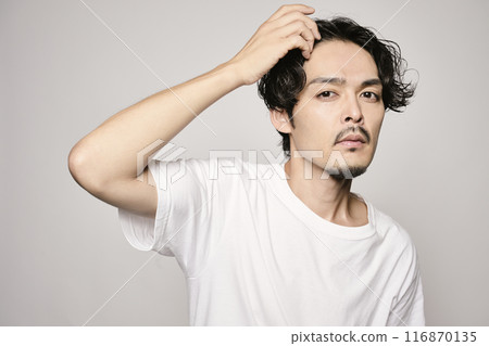一個男人在白色背景下撫摸他的頭髮 一個男人在白色背景下撫摸他的頭髮 116870135