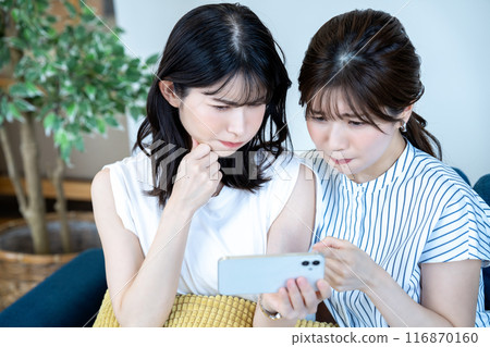 兩名婦女在智慧型手機上觀看視頻 116870160