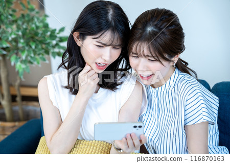 兩名婦女在智慧型手機上觀看視頻 116870163