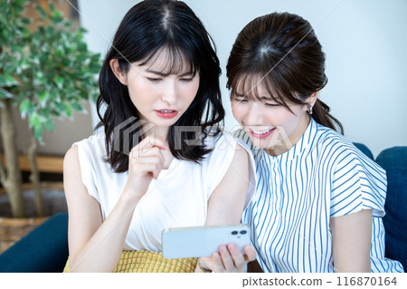 兩名婦女在智慧型手機上觀看視頻 116870164