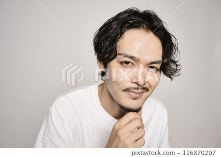 A man holding his hand on his cheek against a white background 116870207