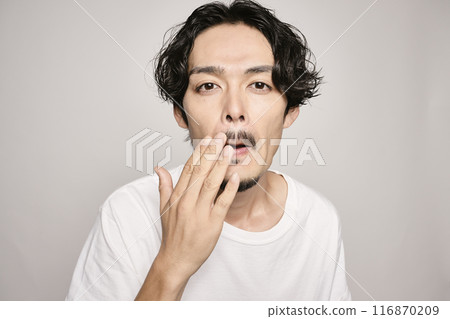 A man holding his hand on his cheek against a white background 116870209