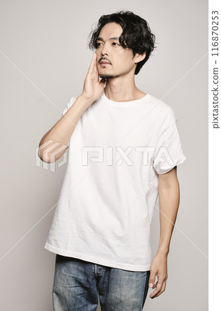 A man holding his hand on his cheek against a white background 116870253