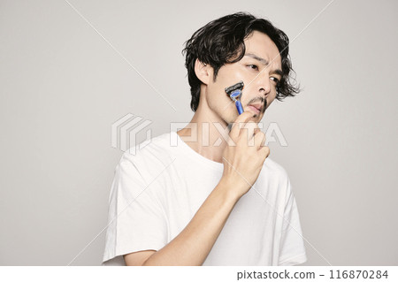 一個男人在白色背景下用剃刀剃須 一個男人在白色背景下用剃刀剃須 116870284