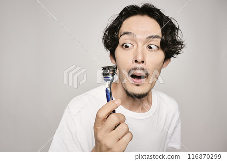 A man shaving with a razor on a white background A man shaving with a razor on a white background 116870299