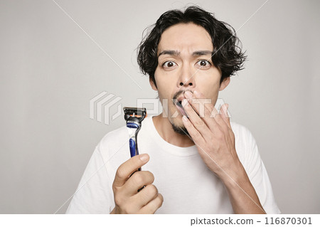 A man shaving with a razor on a white background A man shaving with a razor on a white background 116870301
