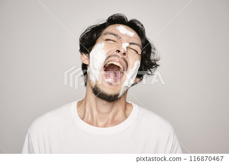 A man washing his face on a white background 116870467