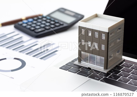 Corporate office building with graphs, laptop and calculator Corporate office building with graphs, laptop and calculator 116870527
