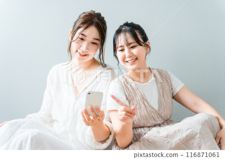 Women, friends, mom friends, and colleagues who use smartphones together at home Women, friends, mom friends, and colleagues who use smartphones together at home 116871061