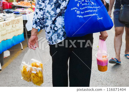 A woman shopping at a market in Bangkok, Thailand A woman shopping at a market in Bangkok, Thailand 116871404